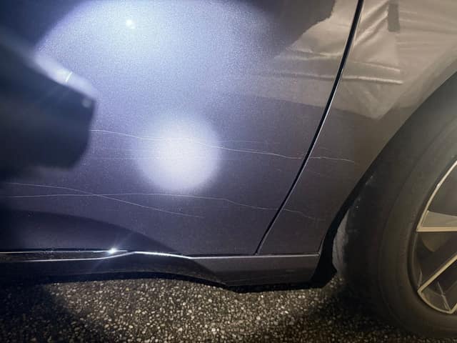 Scratches on the rear door under a flashlight, before