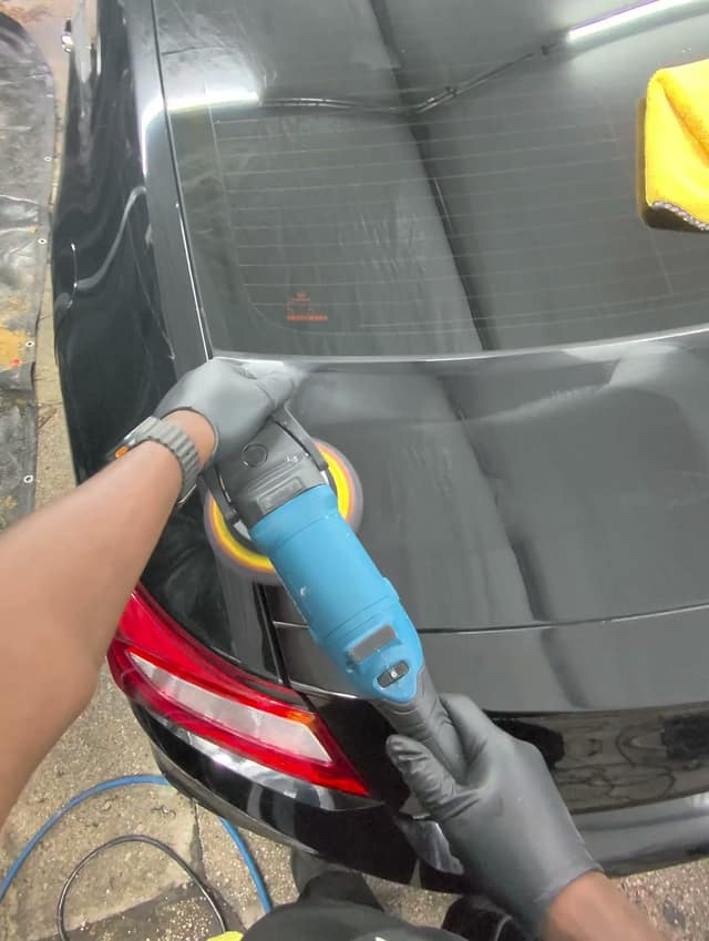 Polishing next to the taillight of a black Honda Accord coupe