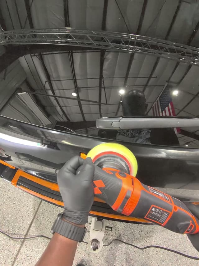 Polishing black paint under shop lighting, during training